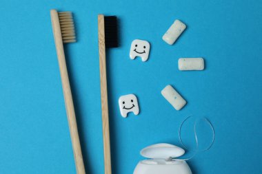 ağız gargarası, diş fırçası, mavi arka planda diş bakımı araçları