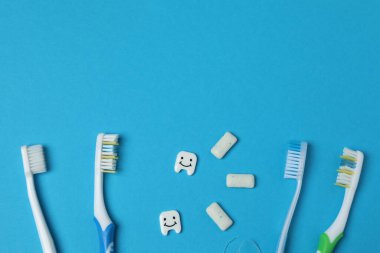 çene modeli, diş fırçası, mavi arkaplanda diş bakımı araçları