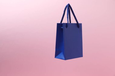 Turuncu arka planda pembe saplı mavi alışveriş çantası