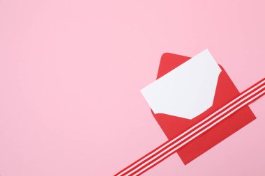 Pembe arka planda kurdeleli kırmızı zarf