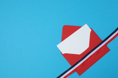 mavi arkaplanda kurdeleli kırmızı zarf