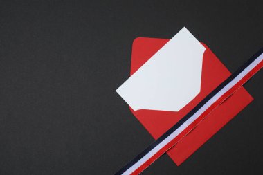 Siyah arkaplanda kurdele olan kırmızı zarf