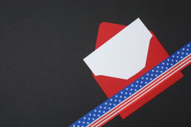 Siyah arkaplanda kurdele olan kırmızı zarf