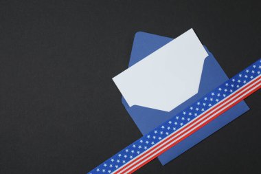 Siyah arkaplanda kurdele olan mavi zarf