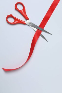 Beyaz arka planda kırmızı kurdele ve makas, düz tasarım. Metin için yer.