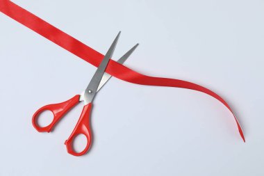 Beyaz arka planda kırmızı kurdele ve makas, düz tasarım. Metin için yer.