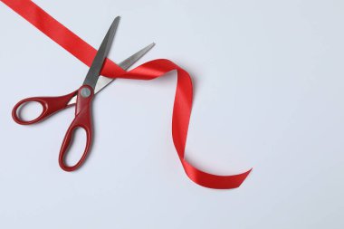 Beyaz arka planda kırmızı kurdele ve makas, düz tasarım. Metin için yer.