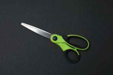 Siyah arka planda makas, düz tasarım. Metin için yer.