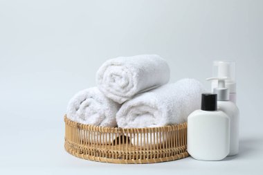 Beyaz arka planda havlu ve banyo aksesuarları.