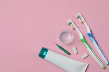 Diş fırçası ve diş macunu, pembe arka planda gargara. Diş bakımı.