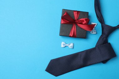 Babalar Günü. Mavi arka planda hediye kutusu, bardak, kahve ve kravat olan kompozisyon.