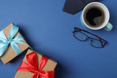 Babalar Günü. Hediye kutusu, bardak, kahve fincanı ve koyu mavi arka planda kravat..