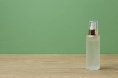 Ahşap bir masada yeşil arka planı olan beyaz tuvalet malzemeleri.