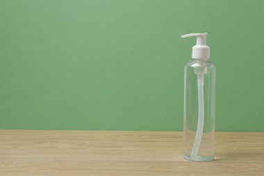 Ahşap bir masada yeşil arka planı olan beyaz tuvalet malzemeleri.