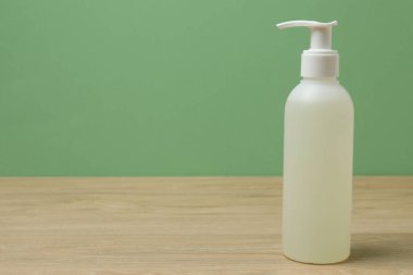 Ahşap bir masada yeşil arka planı olan beyaz tuvalet malzemeleri.