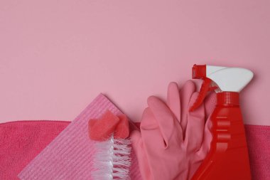 Temizlik ürünü, sünger, pembe arka planda eldivenler.