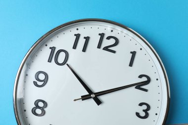 Mavi bir arka plan üzerinde duvar saati