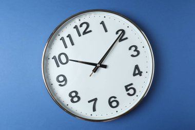 Mavi bir arka plan üzerinde duvar saati