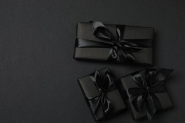 Siyah arkaplanda siyah kurdeleli siyah hediye kutuları