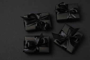 Siyah arkaplanda siyah kurdeleli siyah hediye kutuları