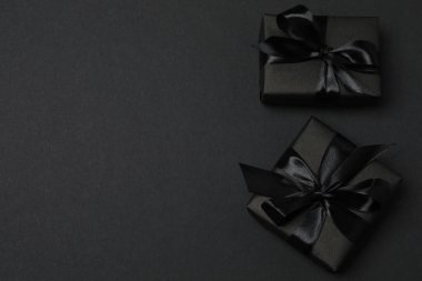 Siyah arkaplanda siyah kurdeleli siyah hediye kutuları