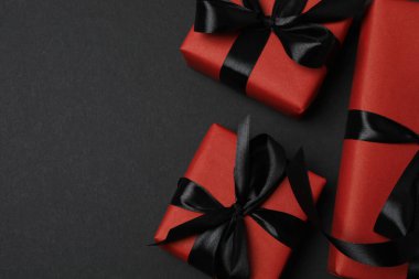 Siyah arkaplanda siyah kurdeleli kırmızı hediye kutuları