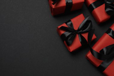 Siyah arkaplanda siyah kurdeleli kırmızı hediye kutuları