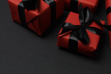 Siyah arkaplanda siyah kurdeleli kırmızı hediye kutuları