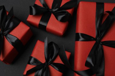 Siyah arkaplanda siyah kurdeleli kırmızı hediye kutuları