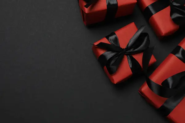 Siyah arkaplanda siyah kurdeleli kırmızı hediye kutuları