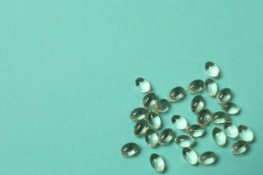 Yeşil arka planda vitamin hapları ve şişe, üst manzara. Metin için boşluk