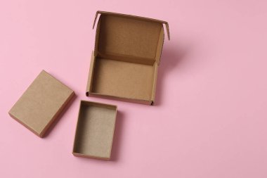 Pembe arka planda kapağı olan boş kağıt kutu, üst görünüm