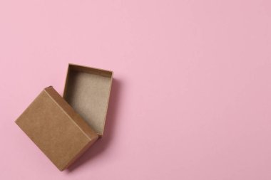 Pembe arka planda kapağı olan boş kağıt kutu, üst görünüm