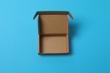 Mavi arka planda kapağı olan boş kağıt kutu, üst görünüm