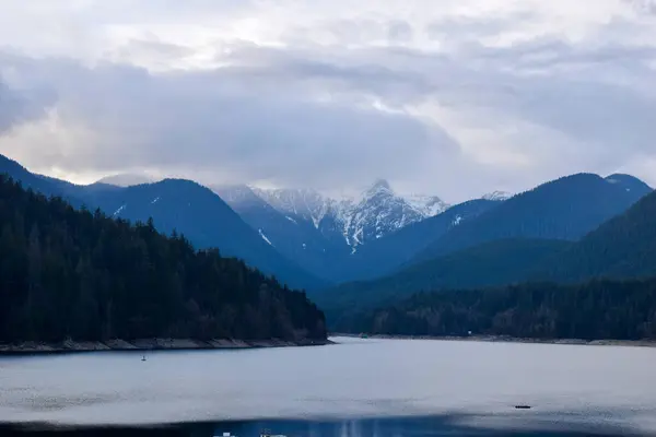 Kuzey Vancouver 'daki Cleveland Baraj Gölü' nün göz kamaştırıcı manzarası, yemyeşil ormanlar ve sisli dağ tepeleriyle çevrili, İngiliz Kolombiyası 'nın vahşi doğasının güzelliğini yansıtıyor.