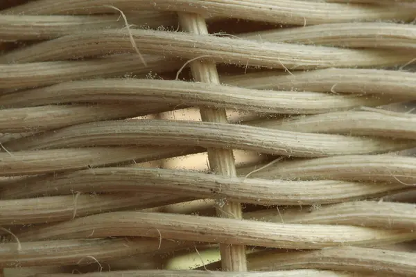 Örülmüş rattan dokusunun makro görüntüsü. Detaylı doğal lifler ve birbirine karışmış ince toz parçacıkları gösteriyor.