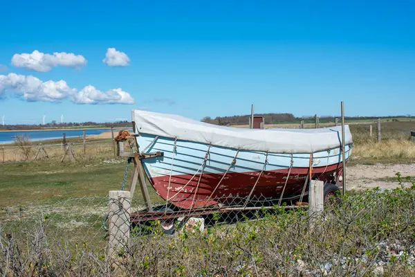 Baltık Denizi kıyısında bir tekne. Bahar geldi. Poster.