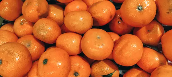 Canlı, taze toplanmış mandalina yığını parlak turuncu renklerini ve doğal dokusunu sergiliyor. Sağlıklı ürün imgeleri için mükemmel..