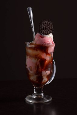 Çikolatalı kurabiyeyle kaplı ve bol soslu kremalı bir bardak, cazip bir tatlı sunumu yaratır..