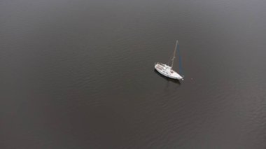Tomin Barajı 'nın sakin sularında yüzen üç yelkenli.