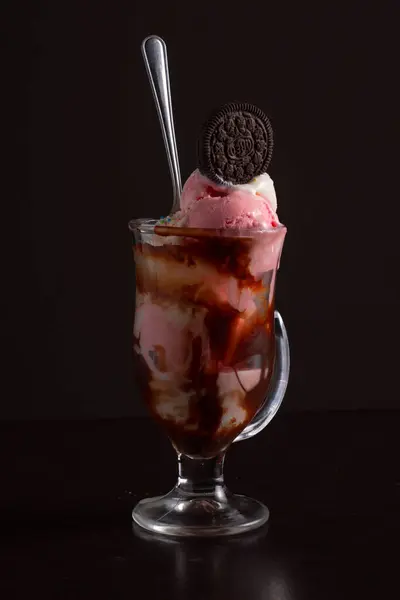 Çikolatalı kurabiyeyle kaplı ve bol soslu kremalı bir bardak, cazip bir tatlı sunumu yaratır..