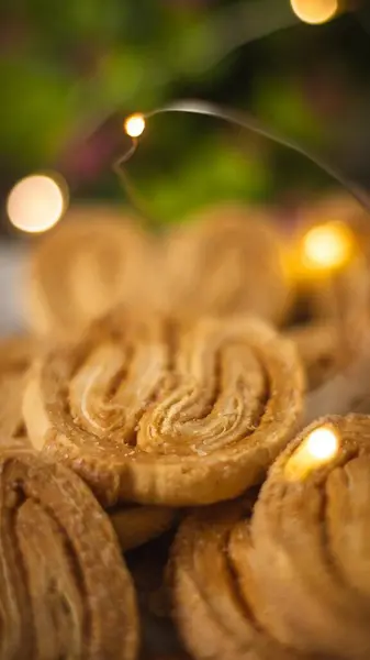 Yumuşak bir bokeh arka planı ve ışık fişekleri olan kalp şeklinde bir kurabiye. Yemek ve tatlı temaları için ideal.