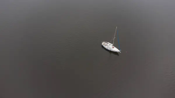 Tomin Barajı 'nın sakin sularında yüzen üç yelkenli.