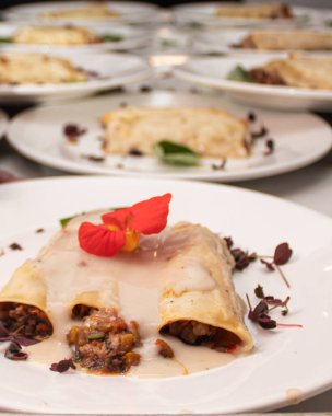 Bir ziyafette servis edilen peynirli ve kırmızı çiçekli nefis gurme yemekleri..