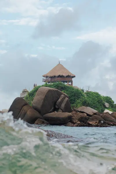 Tayrona Park, Santa Marta 'da kayalar ve yemyeşil bitki örtüsüyle çevrili bir tepedeki kır evi..