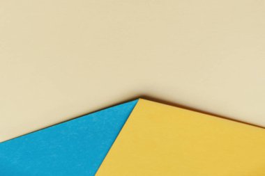 Abstract geometric paper background similar to blue yellow arrow. Colors of State Flag of Ukraine. Copy Space for text. Soft Selective focus