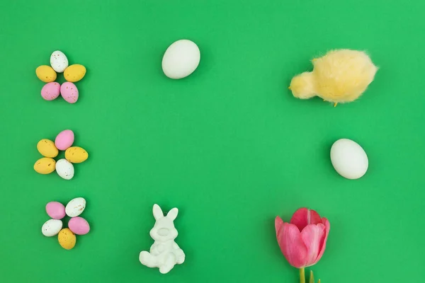 イースターの背景 チョコレートと鶏の卵 ウサギ ピンクのチューリップと緑の背景に小さな雛とイースターフレーム 最小限のコンセプト 最上階だ テキスト用のコピースペース付きカード — ストック写真