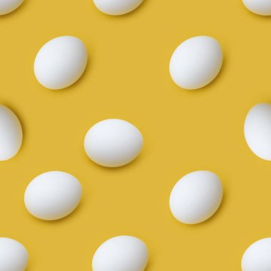 Sarı arka planda kusursuz beyaz tavuk yumurtası deseni. Minimum gıda konsepti. Boşluğu Kopyalayan Paskalya.