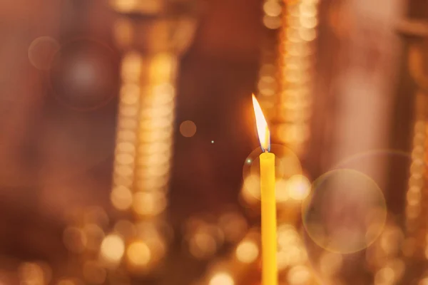 stock image Candle burning in golden church background. Card with Copy Space for text.