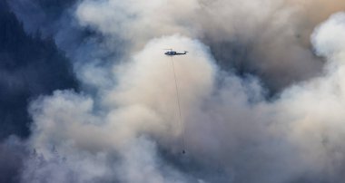 Sıcak bir yaz günü, Hope yakınlarındaki dağda, BC Orman Yangını ve Dumanı 'nın üzerinde uçan Wildfire Servis Helikopteri. British Columbia, Kanada. Doğal Felaket